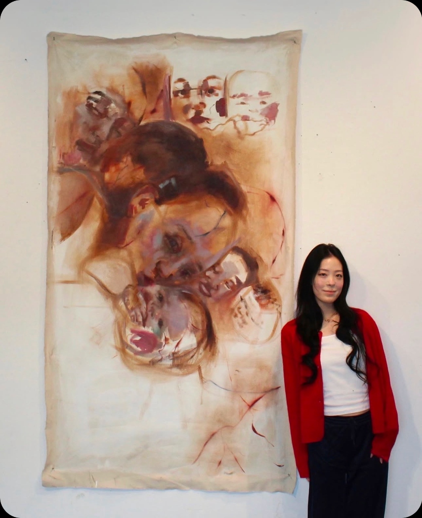 Haven standing next to her canvas painting